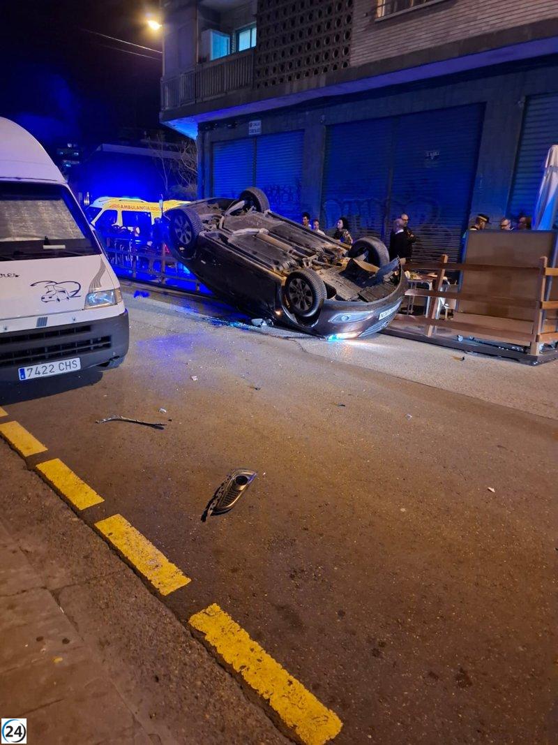 Accidente en Zaragoza: Vehículo volcado tras colisionar con furgoneta estacionada y velador.